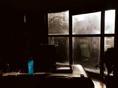 Blue Plastic Tumbler On Wooden Table Beside Chair In Room photo