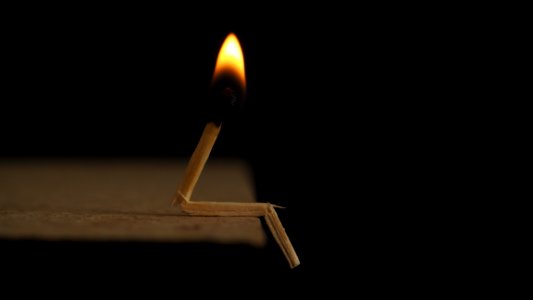 Lighted Matchstick On Brown Wooden Surface