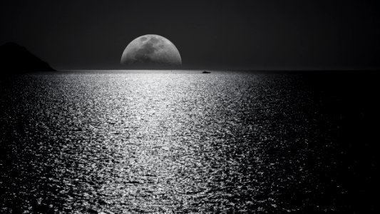 White And Black Moon With Black Skies And Body Of Water Photography During Night Time photo
