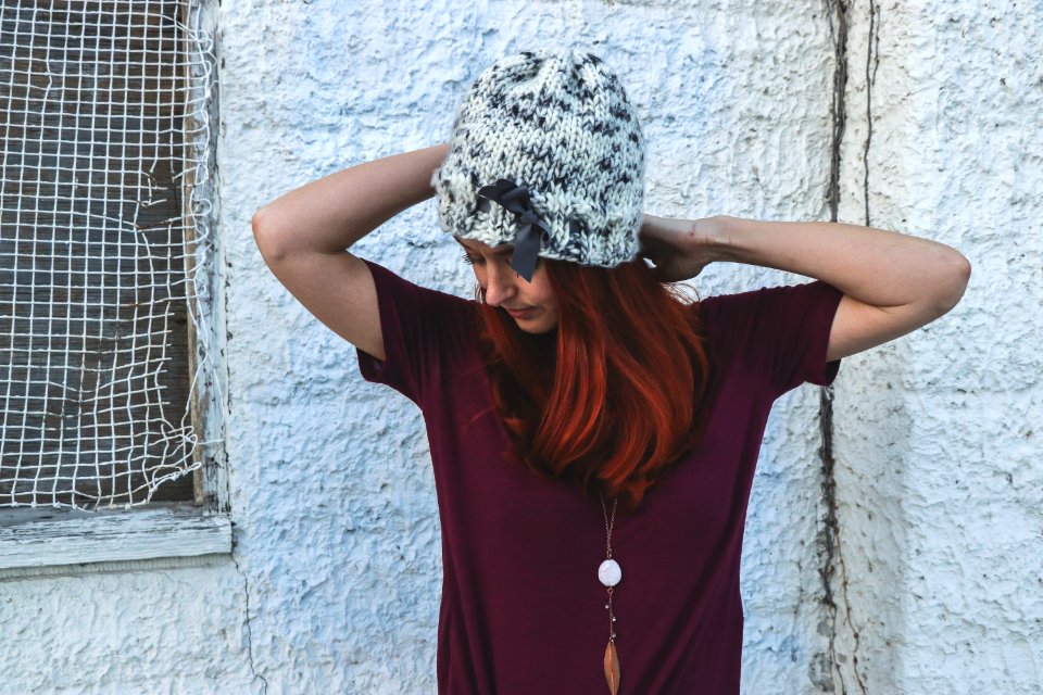 Woman In White And Black Knit Cap Posing Near White Wall