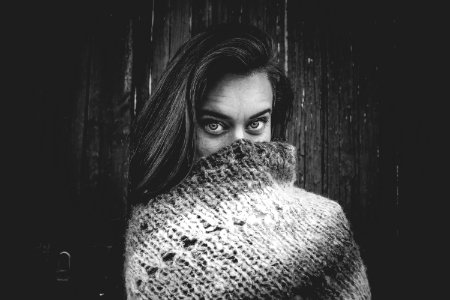 Grayscale Photo Of Woman Covering Mouth With Knitted Textile photo