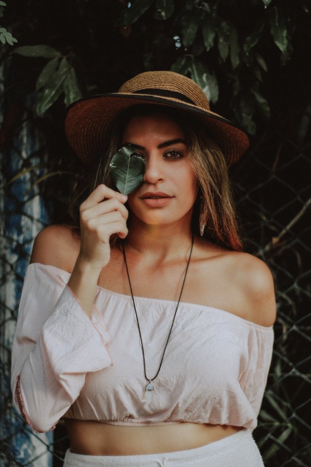Woman In Crop Top Holding Leaf Covering Right Eye