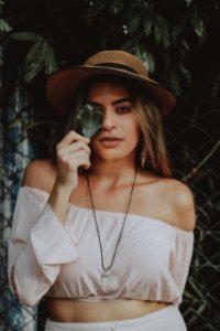 Woman In Crop Top Holding Leaf Covering Right Eye photo