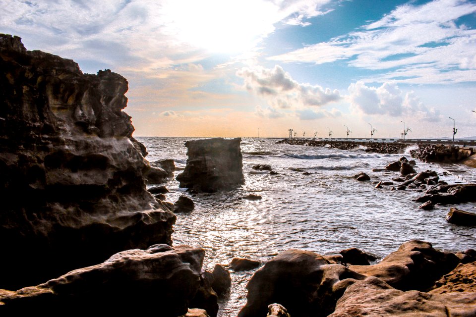Landscape Photography Of Rocks Surrounded By Body Of Water