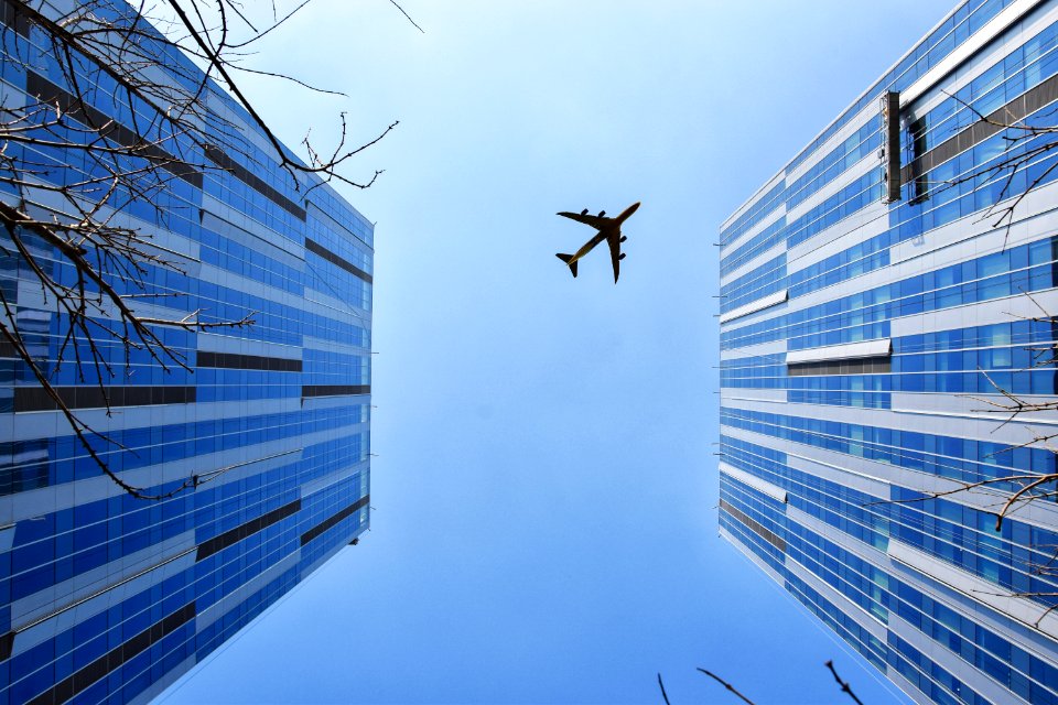 Airplane Near Blue And Grey Building