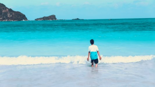 Photo Of Man Walking By The Seashore photo