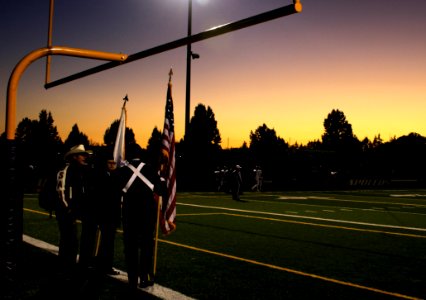 Four People Standing Under On Football Goal During Sunrise photo