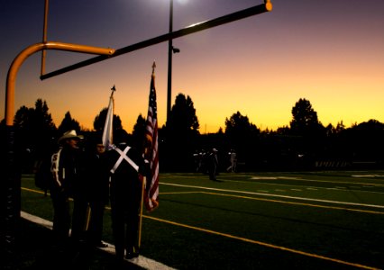 Four People Standing Under On Football Goal During Sunrise