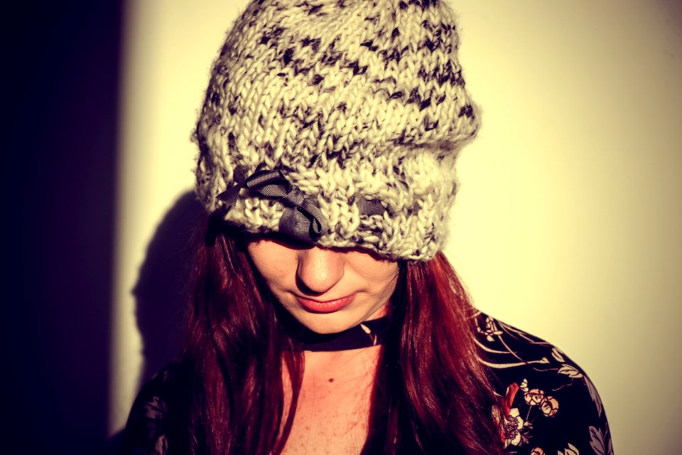 Woman Wearing Black And Gray Knit Cap In The White Wall Paint Room photo