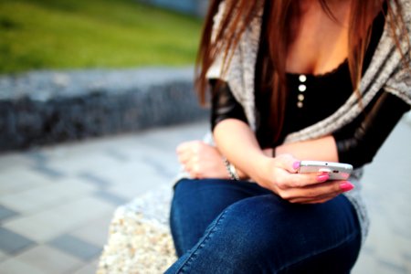 Woman In Black Elbow Sleeve Shirt And Blue Denim Jeans Sitting On The Grey Rock During Daytime photo