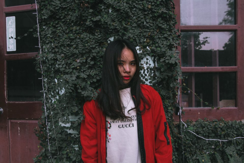 Photo Of Woman Standing Near Window Wearing Red Jacket