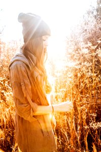 Woman In Black Beanie Standing Next To Tall Grass photo