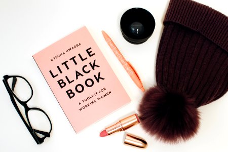 Little Black Book Beside Eyeglasses And Lipstick Case
