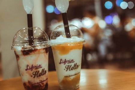 Two Liferia Hello Coffee Drinks On Brown Wooden Table photo