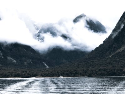 Photography Of Body Of Water Surrounded By Mountains And Fogs photo