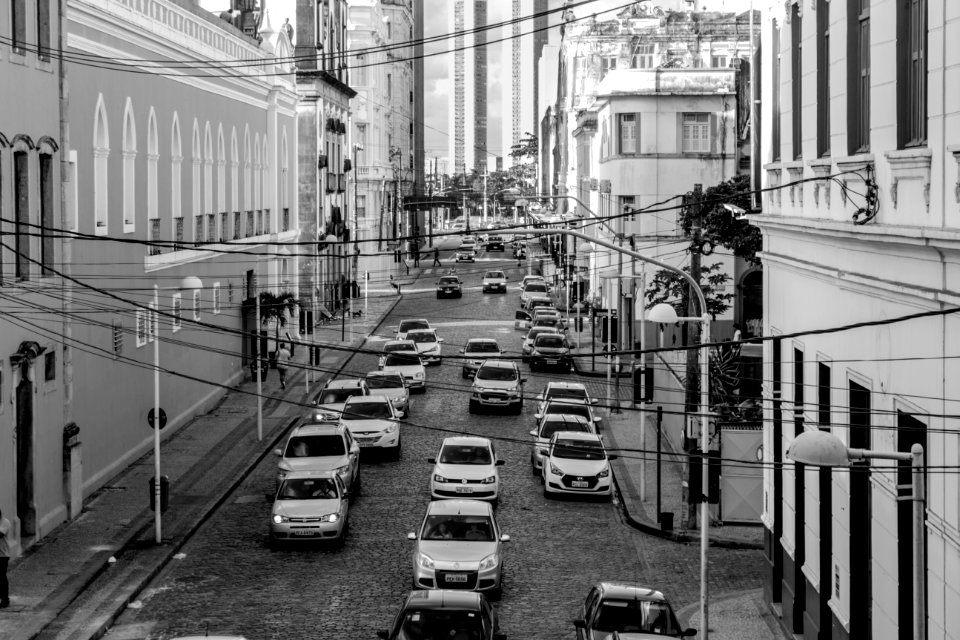 Grayscale Photo Of Assorted Cars At The Middle Of High Rise Buildings photo