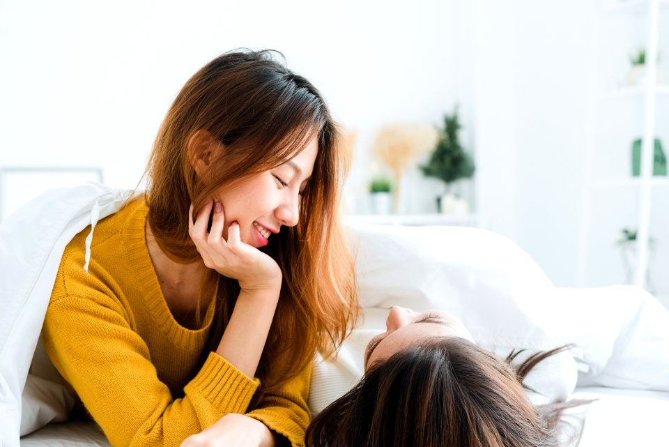 Woman Wearing Sweatshirt Lying On White Mattress