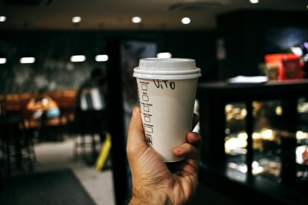 Person Holding Labeled Disposable Cup photo