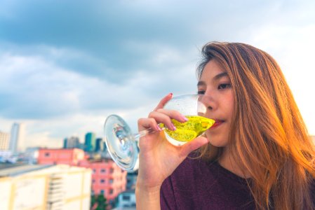 Woman In Purple Top Drinking On Clear Wine Glass