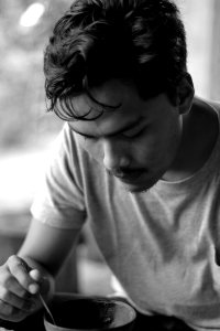 Gray Scale Photo Of Man Holding Bowl And Spoon