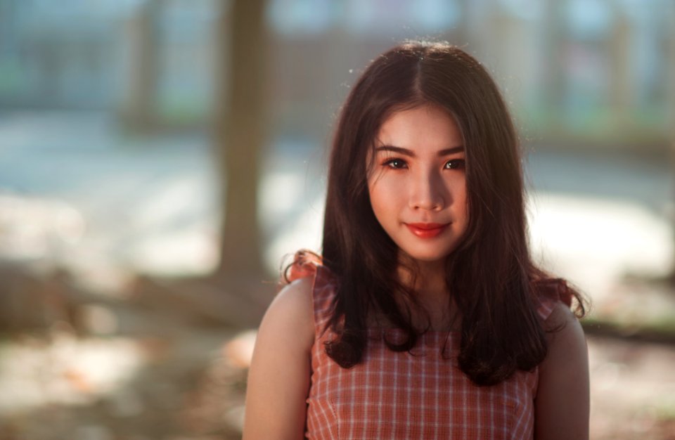 Selective Focus Photography Of Woman With Pink And White Sleeveless Top Standing Behind Tree Trunk