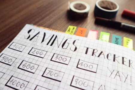 Savings Tracker On Brown Wooden Surface photo