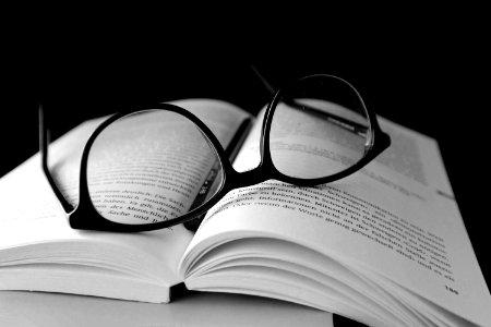 Black Framed Wayfarer Eyeglasses On Book photo