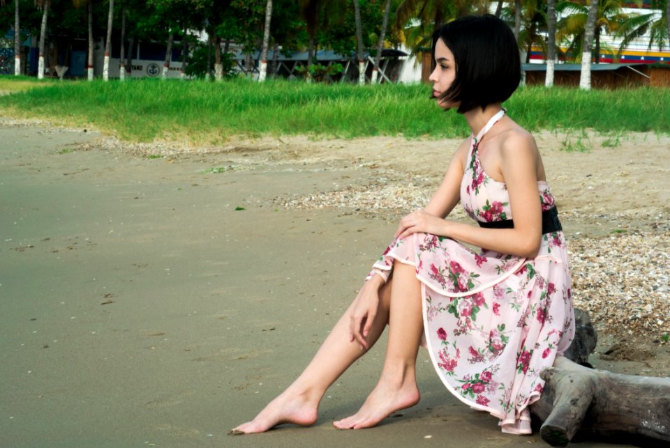 Woman In Pink Floral Halter Dress Seating In Driftwood