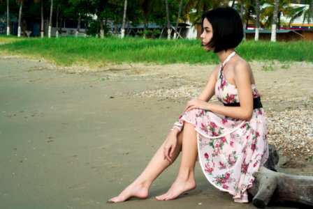 Woman In Pink Floral Halter Dress Seating In Driftwood