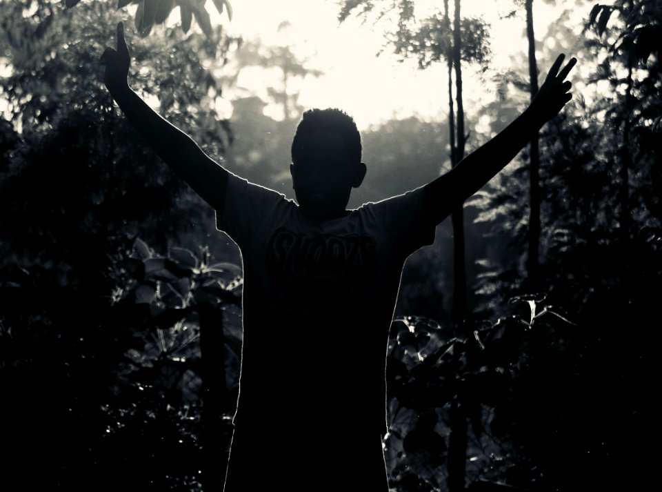 Gray Scale Photo Of Man In White Shirt Raising His Hand Near Plants photo