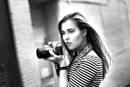 Grayscale Photo Of Woman Holding A Dslr Camera photo
