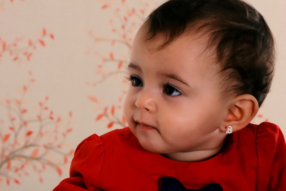 Baby Wearing Red Crew-neck Shirt Near Pink And Black Floral Surface