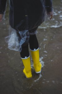 Person Wearing Clear Plastic Raincoat And Pair Of Yellow Rainboots