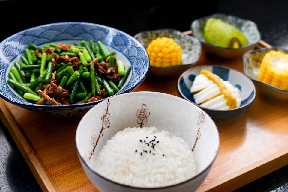 Rice On Bowl Sliced-egg Corn And Vegetable On Table