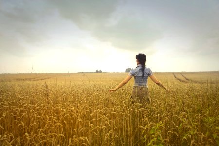Woman Standing On Rice Field During Cloudy Day