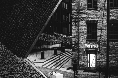 Person Standing Near Bershka Building Grayscale Photography photo