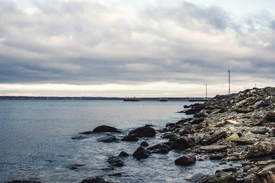 Rocks Beneath The Sea Under Cloudy Sky