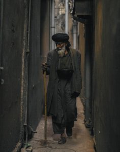 Photo Of An Old Man Walking In The Alley photo