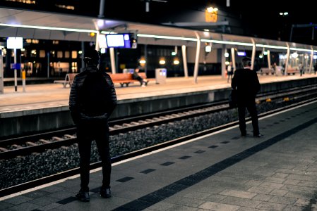 Photo Of Two Men Standing Near Railway Station photo