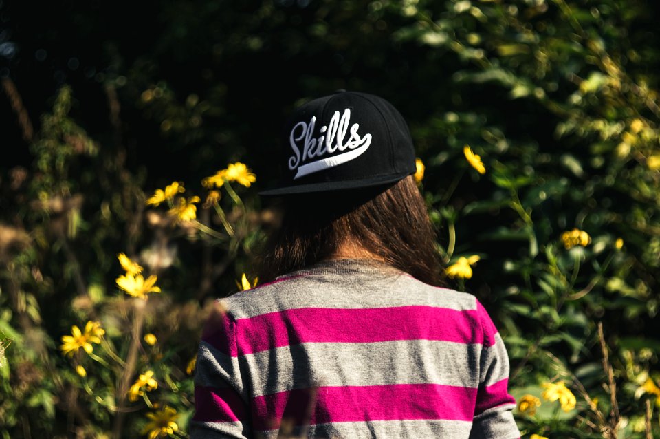 Woman In Gray And Pink Longsleeve Shirt Wearing Black Skill Printed Cap