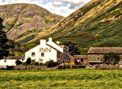 White Concrete Inn Near Green Covered Mountain At Daytime photo