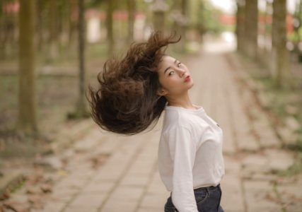 Closeup Photo Of Woman In White Crew-neck Long-sleeved Shirt Shaking Her Hair In The Middle On Road