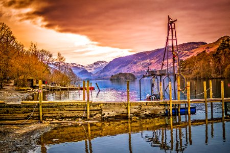 Brown Wooden Bridge Near Mountains And Body Of Water photo