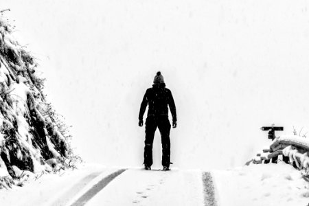 Man Standing On White Snow Covered Ground Beside Mountain photo