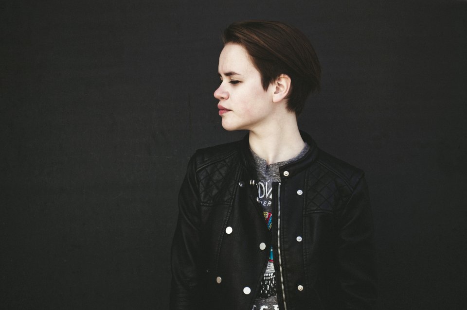 Person Wearing Quilted Black Zip-up Letterman Jacket Facing Side View