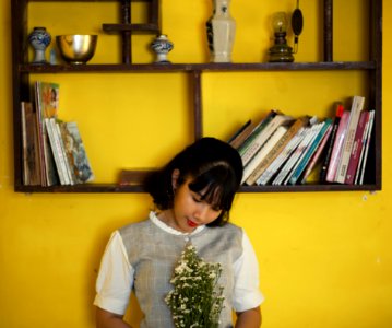 Woman Standing Beside Brown Wooden Shelf