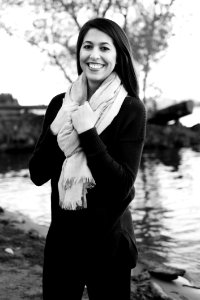 Grayscale Photography Of A Woman Wearing Sweatshirt And Black Pants While Holding Scarf photo