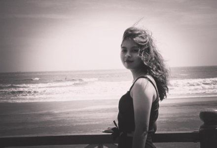 Grayscale Photo Of Woman Wearing Tank Top Standing Near Seashore photo