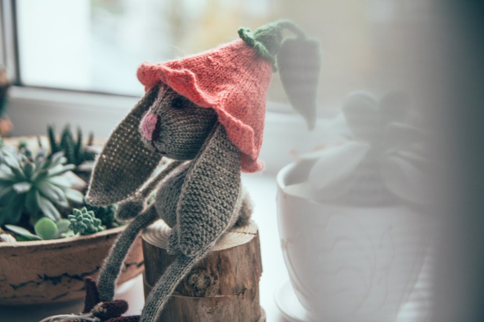 Gray Rabbit Amigurumi Plush Toy On Wood Trunk