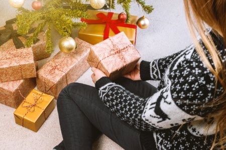 Woman In Sweatshirt And Jeans Holding A Gift Box photo